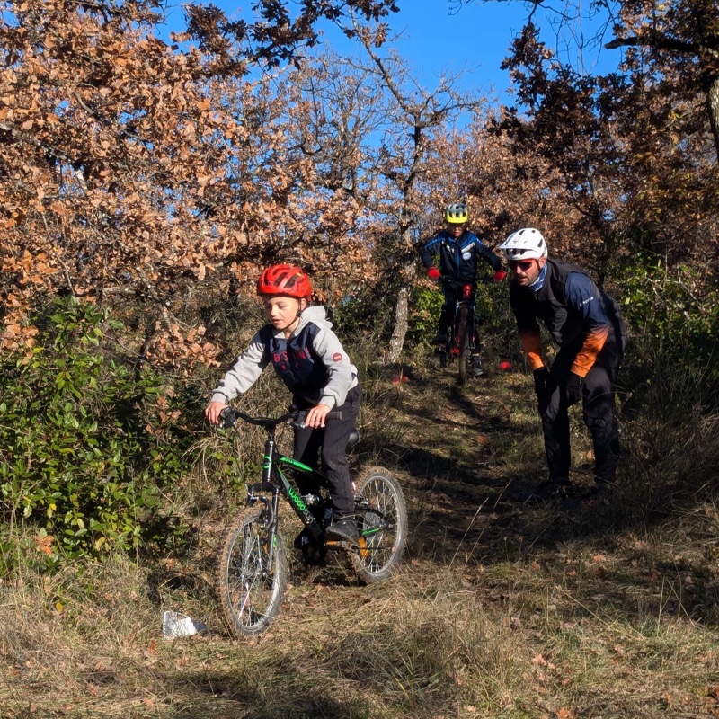 Moniteur de VTT en train d'orienter un enfant durant un cours de pilotage VTT.