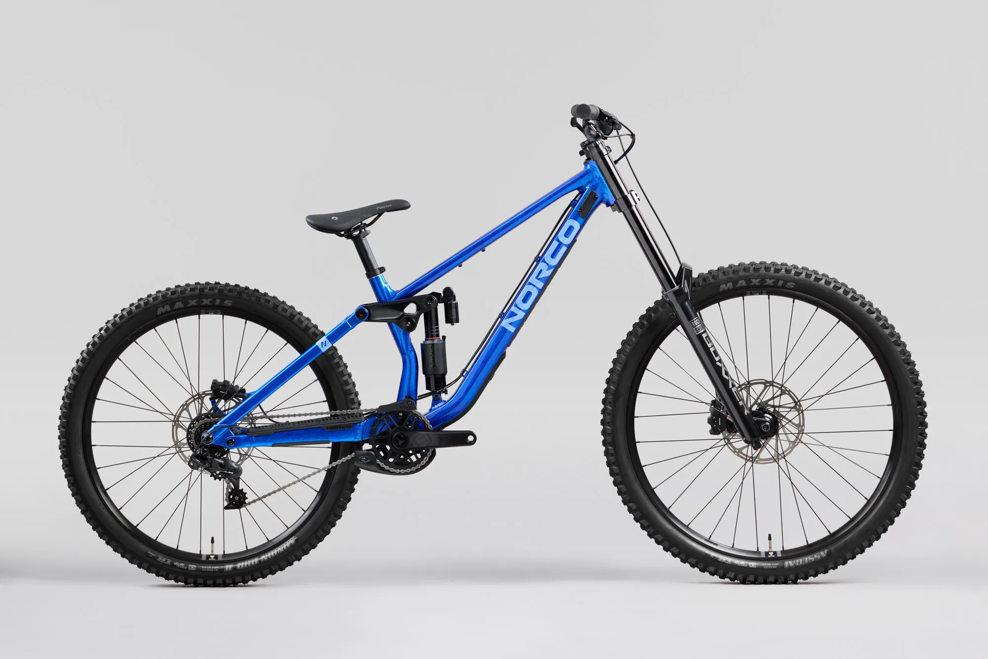 Norco Torrent DH A1 2027 bleu, vue de profil, roue avant à droite : cadre bleu profond, transmission et plateau côté chaîne, guide-chaîne et pédalier visibles.