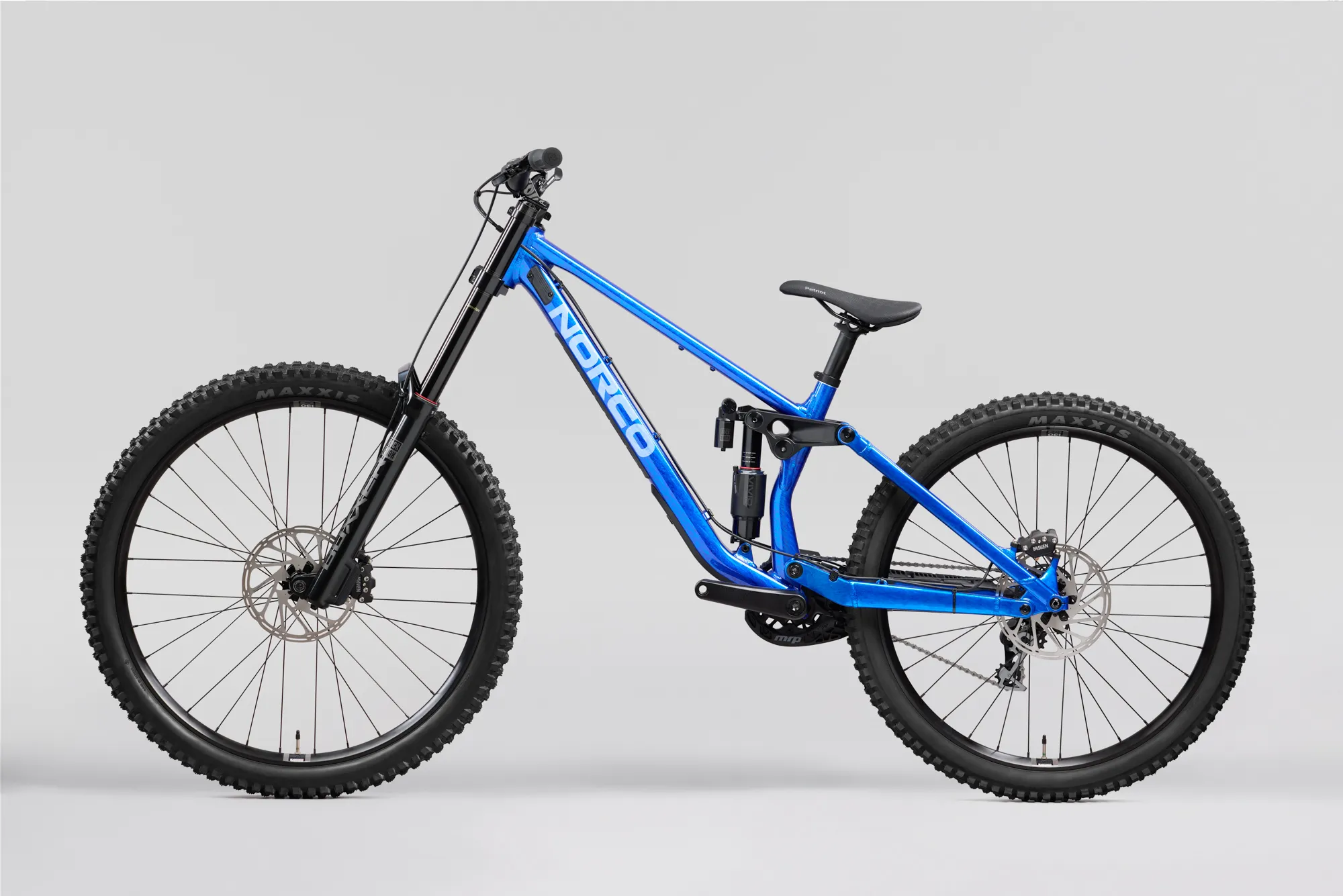 Norco Torrent DH A1 2027 bleu, vue de profil, roue avant à gauche : cadre bleu vif avec logo Norco bleu clair, amortisseur arrière noir, freins à disque et pneus larges à crampons.